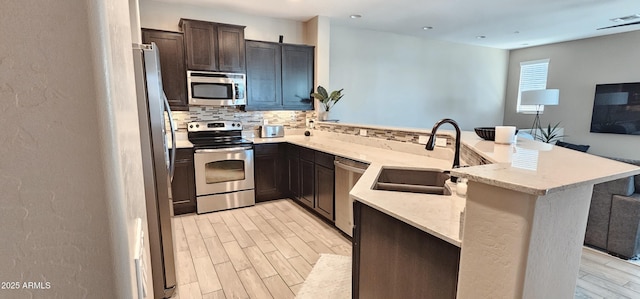 4705 E Red Oak Ln Unit 101, Gilbert, AZ 85297 - kitchen featuring appliances with stainless steel finishes, a peninsula, backsplash, light wood-type flooring, and recessed lighting