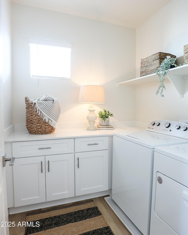 laundry room featuring cabinets, washer and dryer, and light hardwood / wood-style floors