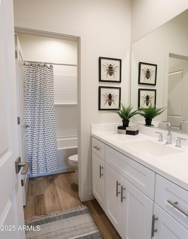 full bathroom featuring hardwood / wood-style flooring, vanity, shower / bath combination with curtain, and toilet