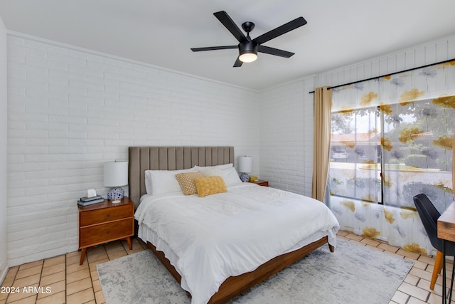 tiled bedroom featuring ceiling fan and brick wall