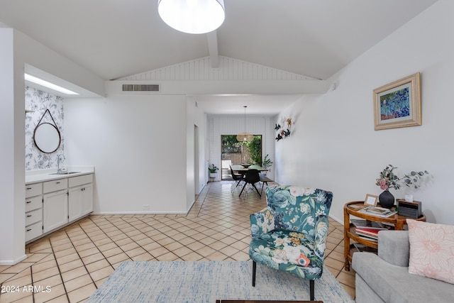 tiled living room featuring lofted ceiling with beams and sink