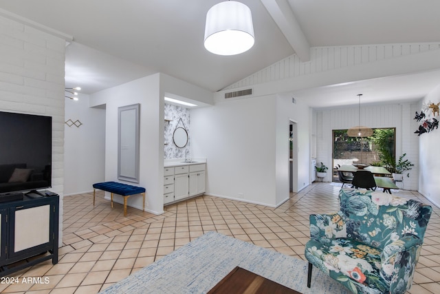 tiled living room with vaulted ceiling with beams and sink