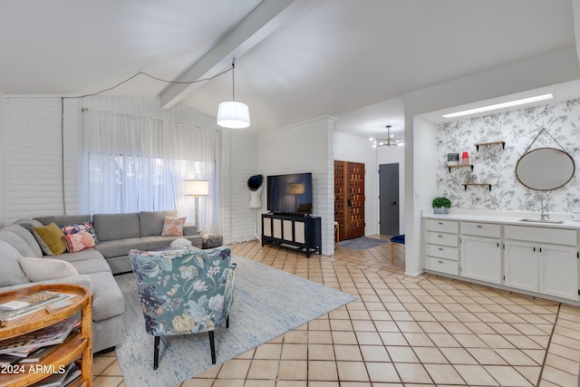 living room with vaulted ceiling with beams, light tile patterned floors, sink, and a chandelier