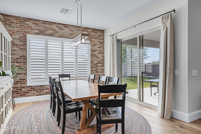 1439 E Mead Dr, Gilbert, AZ 85298 - dining area featuring baseboards, brick wall, and light wood-style flooring