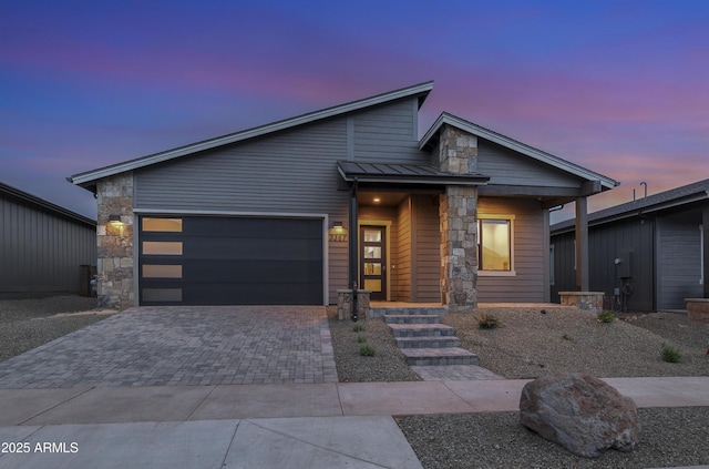 3367 W Lyra Way, Flagstaff, AZ 86001 - view of front facade with stone siding, an attached garage, decorative driveway, a standing seam roof, and metal roof