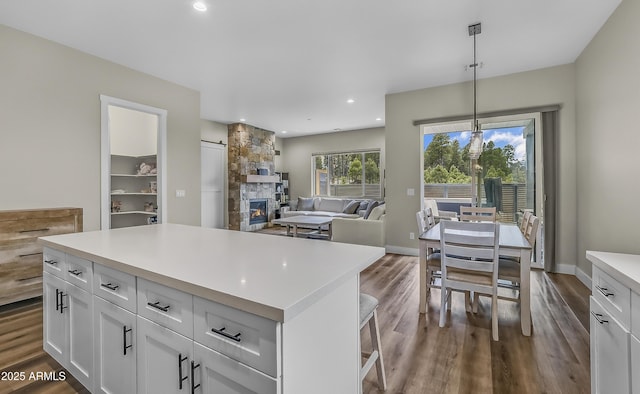 3367 W Lyra Way, Flagstaff, AZ 86001 - kitchen with dark wood-style flooring, light countertops, white cabinets, a fireplace, and recessed lighting