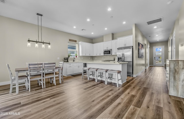 3367 W Lyra Way, Flagstaff, AZ 86001 - kitchen with appliances with stainless steel finishes, plenty of natural light, white cabinetry, a center island, and recessed lighting