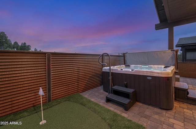 3367 W Lyra Way, Flagstaff, AZ 86001 - patio terrace at dusk featuring a hot tub, a putting area, and a patio