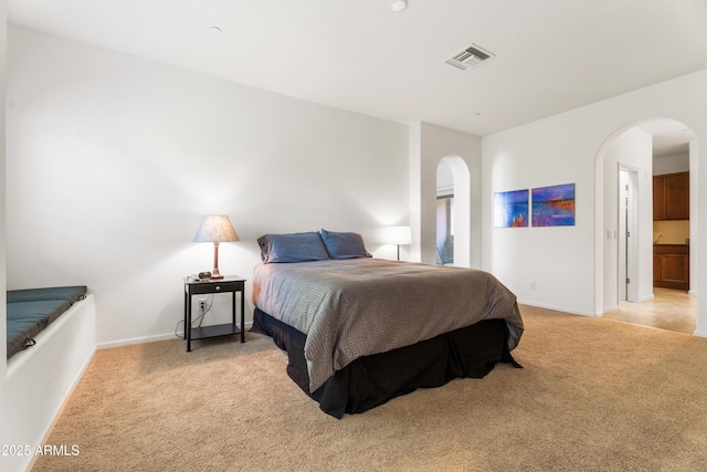 carpeted bedroom featuring ensuite bathroom