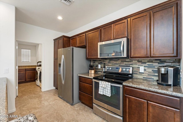 kitchen featuring light stone counters, backsplash, washer / clothes dryer, and appliances with stainless steel finishes