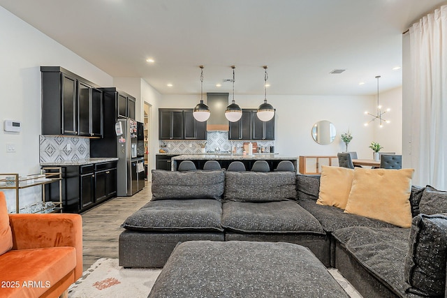 living room with recessed lighting, visible vents, a chandelier, and light wood finished floors