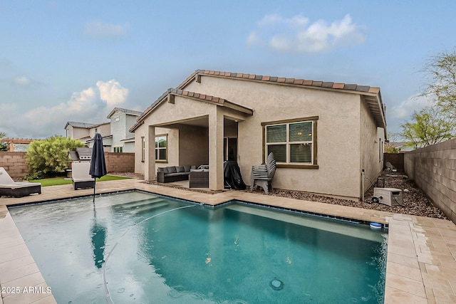 back of property with a patio, a fenced in pool, a fenced backyard, stucco siding, and an outdoor hangout area