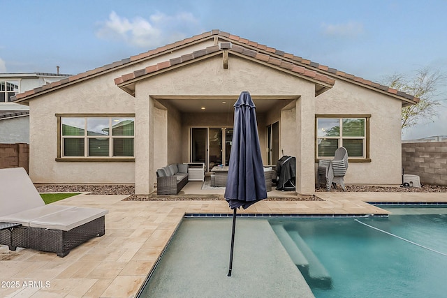 back of house with fence, stucco siding, an outdoor hangout area, an outdoor pool, and a patio