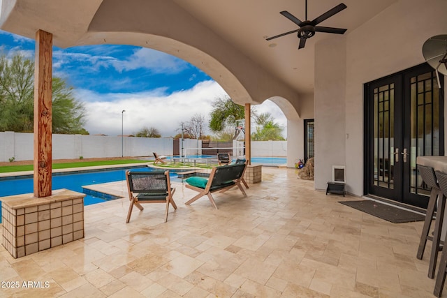 view of patio featuring a fenced backyard, a fenced in pool, ceiling fan, and french doors