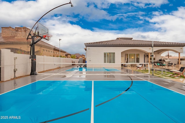 view of sport court with fence and a fenced in pool