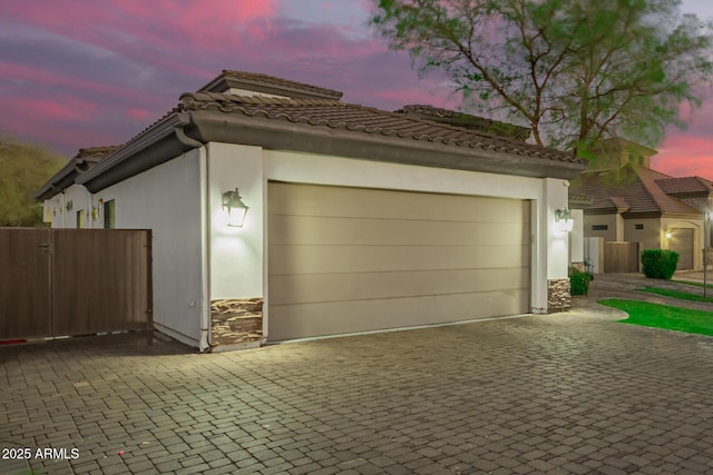 garage featuring driveway and fence