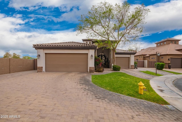 mediterranean / spanish-style house with stone siding, driveway, and a tile roof