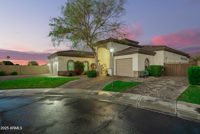 mediterranean / spanish-style house featuring a garage, fence, driveway, and a tile roof