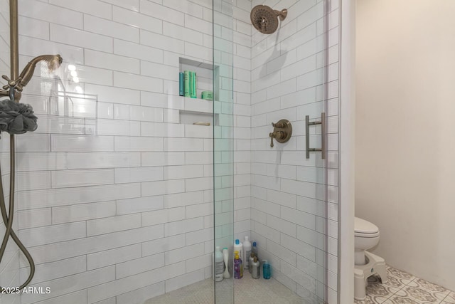 bathroom featuring toilet and a tile shower