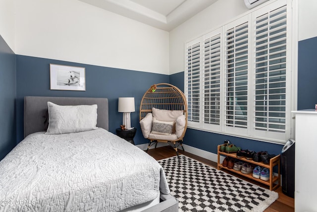 bedroom featuring baseboards and wood finished floors