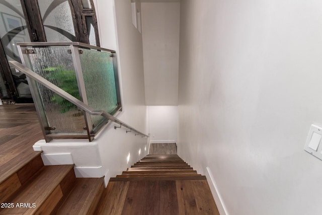 staircase with baseboards and wood finished floors