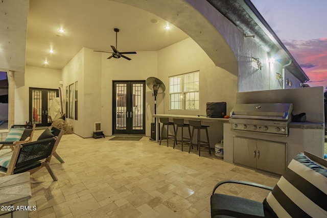 view of patio / terrace with a grill, french doors, outdoor wet bar, and ceiling fan