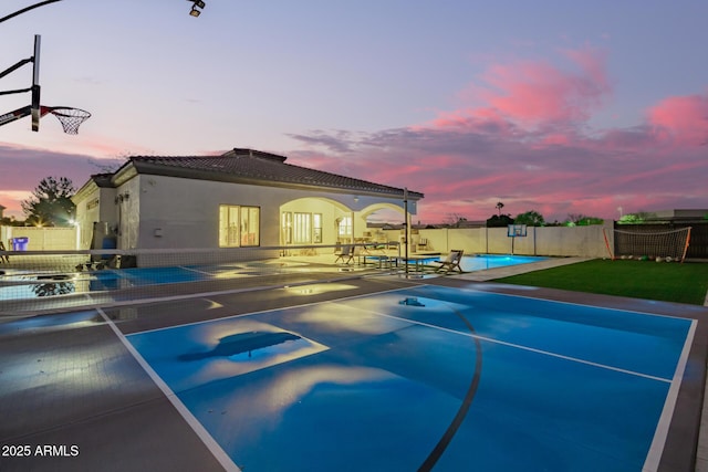 view of basketball court with a fenced in pool and fence