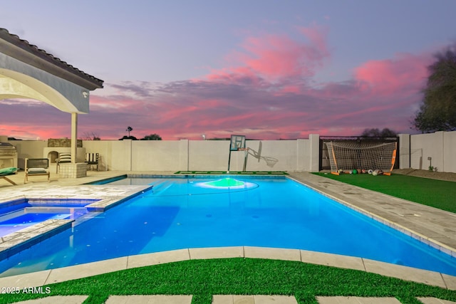 view of pool with a patio area, a pool with connected hot tub, and a fenced backyard