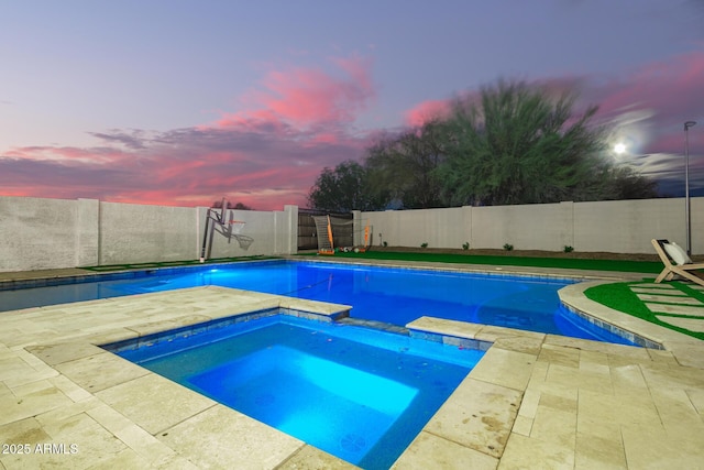 view of pool featuring a patio area, a pool with connected hot tub, and a fenced backyard