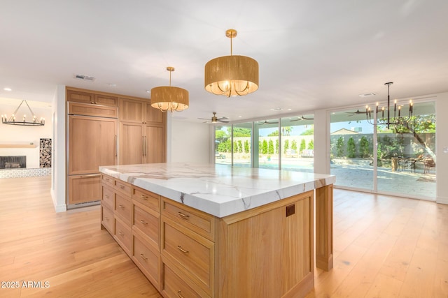 16227 N 63rd Pl, Scottsdale, AZ 85254 - kitchen with a chandelier, paneled refrigerator, light wood finished floors, a kitchen island, and light stone countertops