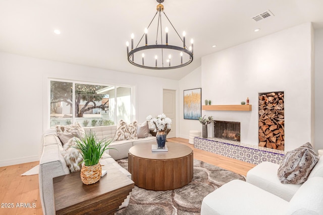 16227 N 63rd Pl, Scottsdale, AZ 85254 - living area featuring wood finished floors, a chandelier, a fireplace with raised hearth, baseboards, and vaulted ceiling