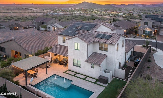 2915 W Night Owl Ln, Phoenix, AZ 85085 - back of property at dusk with a fenced backyard, roof mounted solar panels, a gazebo, stucco siding, and a residential view