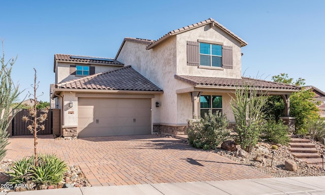 2915 W Night Owl Ln, Phoenix, AZ 85085 - view of front of home with stone siding, stucco siding, solar panels, an attached garage, and decorative driveway
