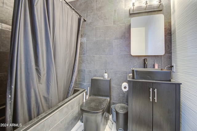 full bathroom with vanity, toilet, shower / bathtub combination with curtain, and tile walls