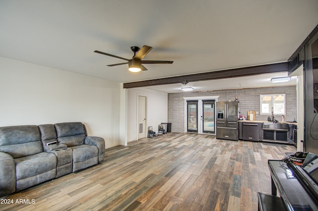 living room with french doors, brick wall, ceiling fan, sink, and hardwood / wood-style flooring