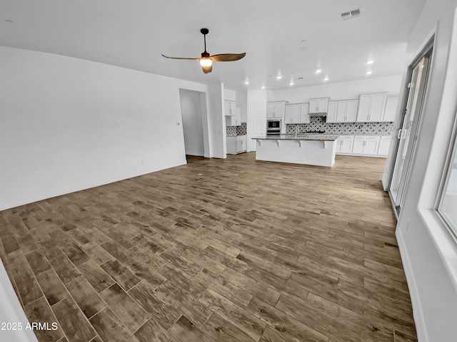 unfurnished living room with a ceiling fan, recessed lighting, visible vents, and wood finished floors