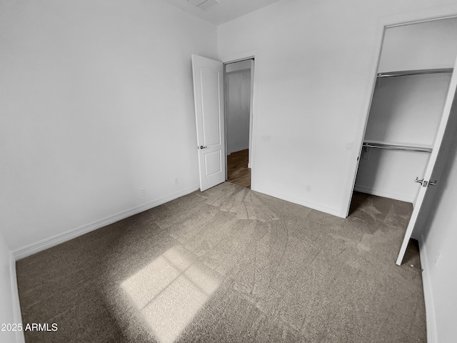 unfurnished bedroom featuring a spacious closet, a closet, carpet, and baseboards