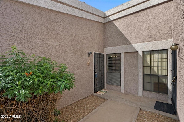 doorway to property featuring a patio and stucco siding