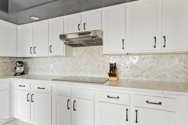 kitchen featuring backsplash, black electric stovetop, and white cabinets