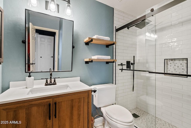 bathroom featuring a shower with door, vanity, and toilet