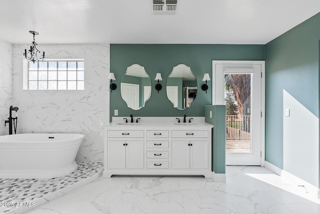 bathroom with vanity, a bathtub, and a notable chandelier