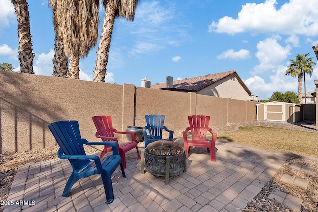 view of patio featuring a storage shed and a fire pit