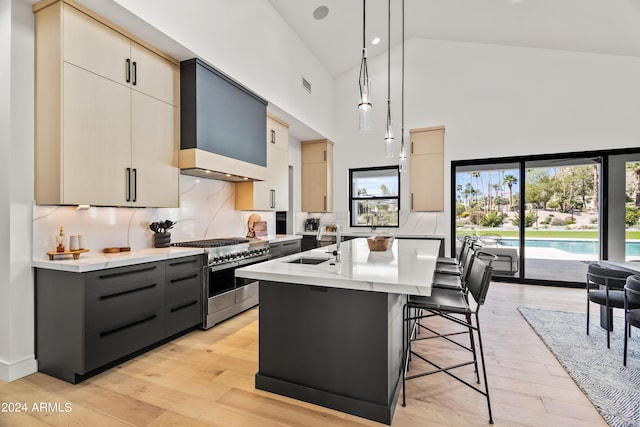 kitchen with double oven range, an island with sink, gray cabinetry, pendant lighting, and sink