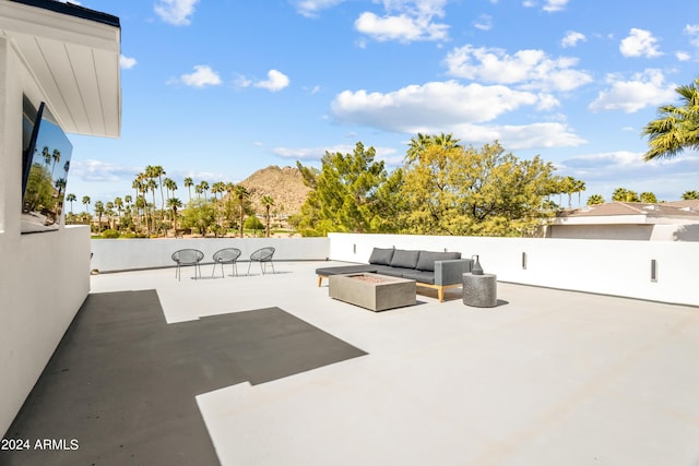 view of patio featuring an outdoor living space with a fire pit and a mountain view