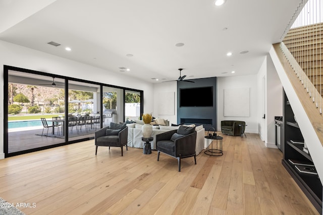 living room featuring ceiling fan and light wood-type flooring