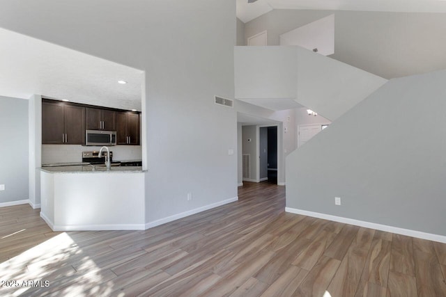 1380 Vista Montana Rd Unit 22, Sedona, AZ 86336 - unfurnished living room featuring light wood-style floors, baseboards, and high vaulted ceiling