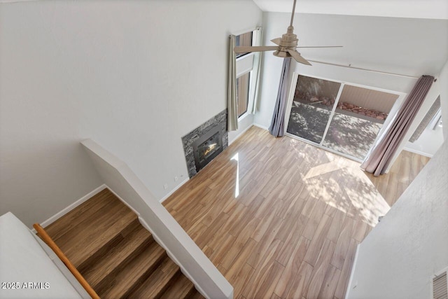 1380 Vista Montana Rd Unit 22, Sedona, AZ 86336 - unfurnished living room featuring ceiling fan, wood finished floors, a glass covered fireplace, baseboards, and lofted ceiling
