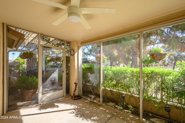 unfurnished sunroom with ceiling fan