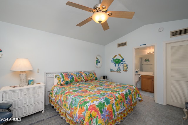 bedroom featuring dark tile patterned flooring, ceiling fan, lofted ceiling, and ensuite bath