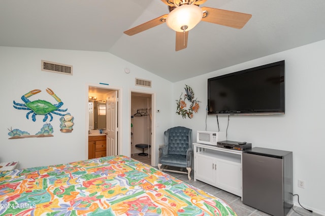 tiled bedroom with connected bathroom, ceiling fan, vaulted ceiling, and stainless steel fridge